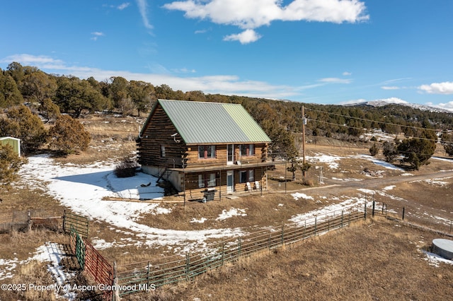 exterior space with fence, metal roof, and log exterior