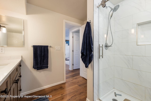 full bathroom featuring a stall shower, wood finished floors, vanity, and baseboards