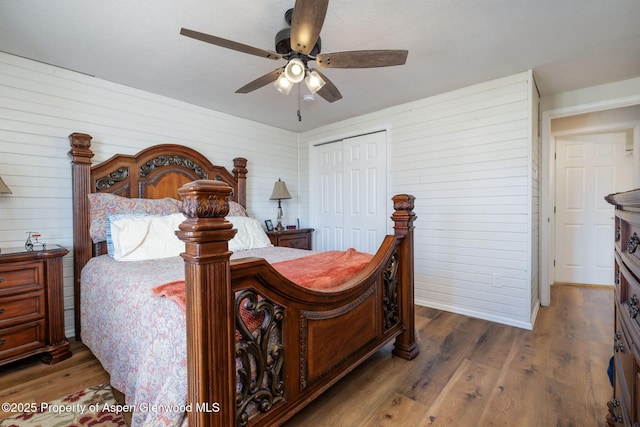 bedroom with a closet, dark wood finished floors, and a ceiling fan