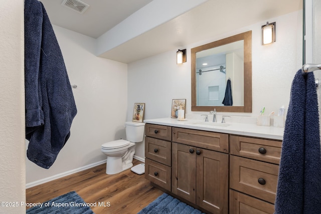 full bath featuring visible vents, toilet, vanity, wood finished floors, and baseboards