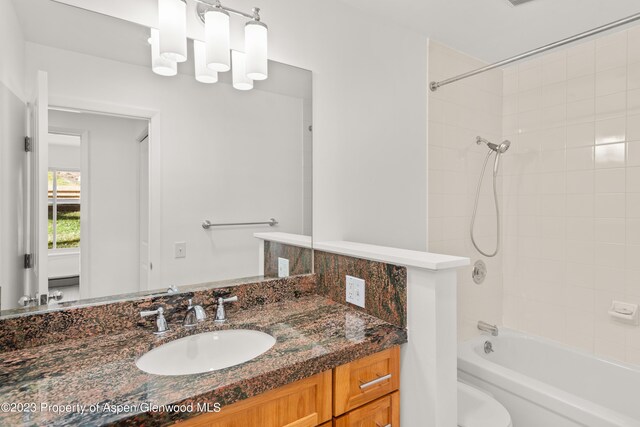 full bathroom with vanity, toilet, and tiled shower / bath combo