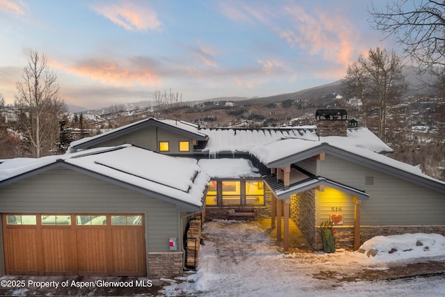 view of front of home with a garage and a mountain view