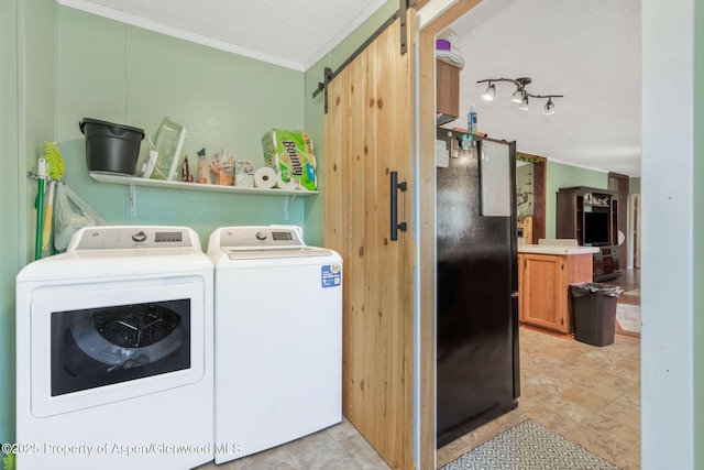 1137 Rose St, Craig, CO 81625 - laundry area featuring washing machine and dryer, a barn door, and ornamental molding