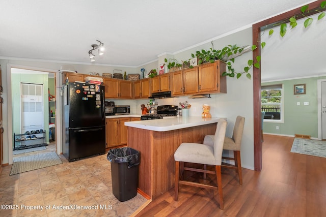 1137 Rose St, Craig, CO 81625 - kitchen featuring freestanding refrigerator, range, stainless steel microwave, light countertops, and a peninsula