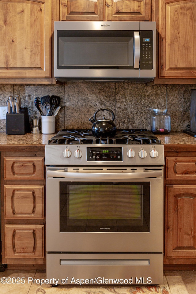 1468 W Main St, Carbondale, CO 81623 - kitchen featuring appliances with stainless steel finishes, decorative backsplash, and brown cabinetry
