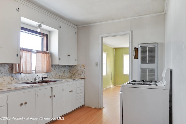 kitchen with tasteful backsplash, a wealth of natural light, stove, and white cabinets