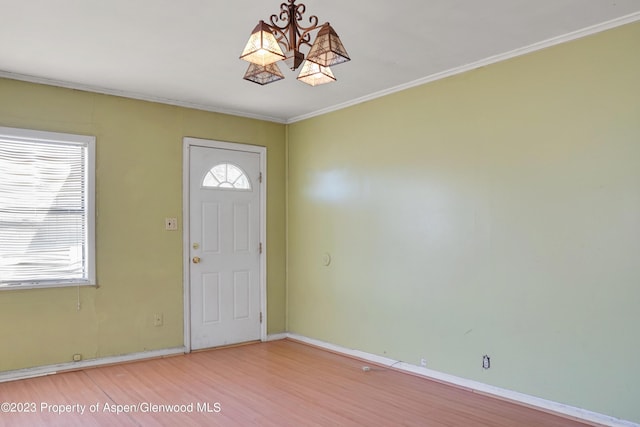 entryway with crown molding, a chandelier, and hardwood / wood-style flooring