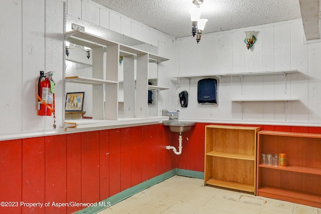 kitchen featuring a textured ceiling and wood walls