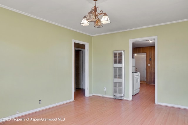 unfurnished room featuring an inviting chandelier, light hardwood / wood-style flooring, and ornamental molding