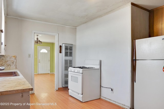 kitchen featuring white appliances, crown molding, sink, a chandelier, and light hardwood / wood-style floors