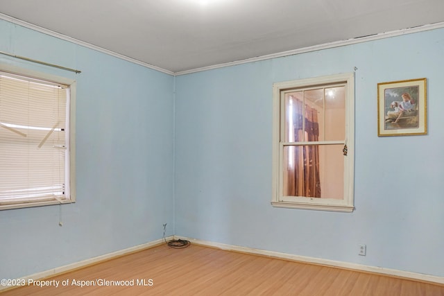 empty room with crown molding and wood-type flooring