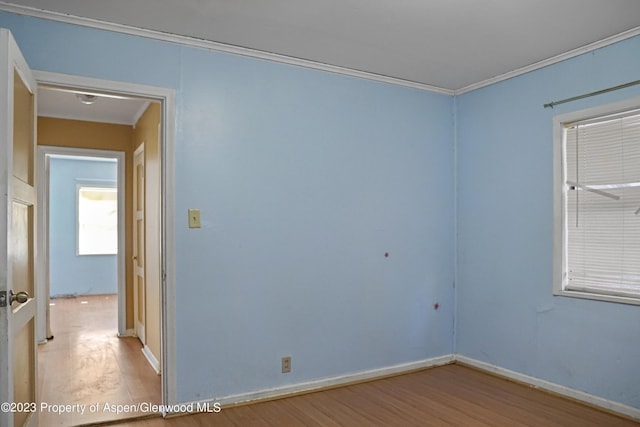 spare room with crown molding and hardwood / wood-style floors