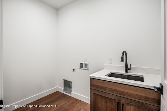 clothes washing area featuring dark wood-type flooring, sink, cabinets, hookup for a washing machine, and electric dryer hookup