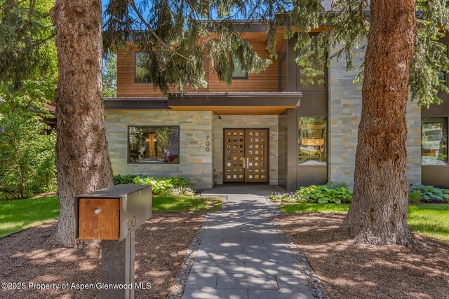 700 W Smuggler St, Aspen, CO 81611 - living room with a towering ceiling, plenty of natural light, wood finished floors, and a fireplace