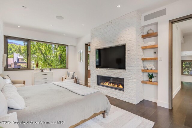 700 W Smuggler St, Aspen, CO 81611 - bedroom with wood finished floors, multiple windows, a stone fireplace, and recessed lighting