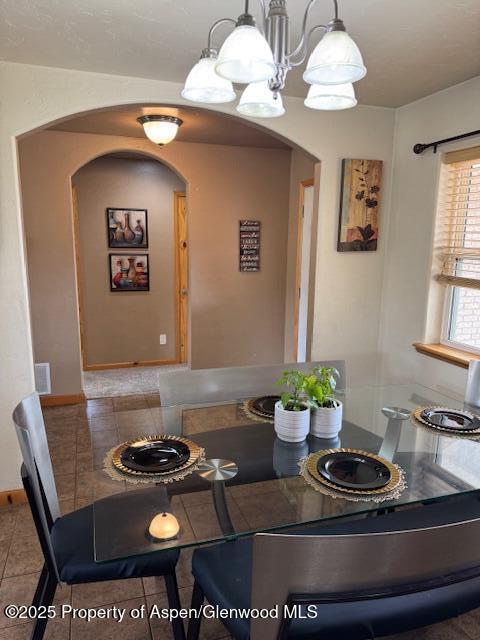 3695 W W 6th St, Craig, CO 81625 - dining room with arched walkways, tile patterned flooring, and a chandelier