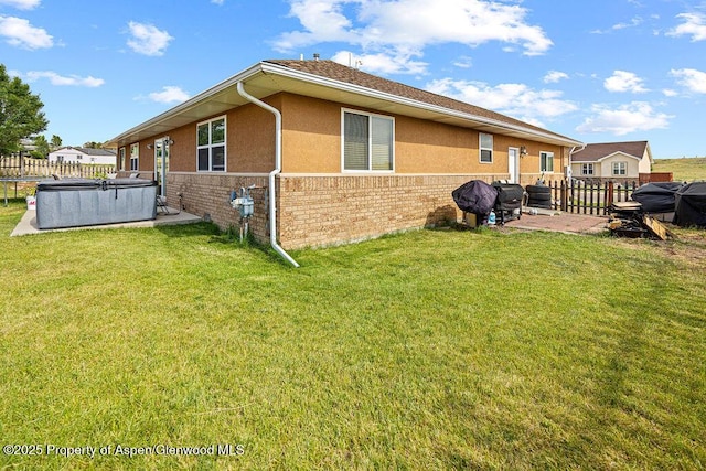 3695 W W 6th St, Craig, CO 81625 - rear view of property with brick siding, a hot tub, and stucco siding