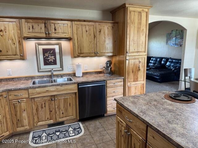 3695 W W 6th St, Craig, CO 81625 - kitchen featuring black dishwasher, a sink, light tile patterned floors, dark countertops, and arched walkways