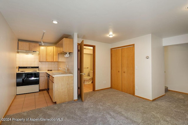 kitchen with sink, light brown cabinets, light carpet, white range, and decorative backsplash