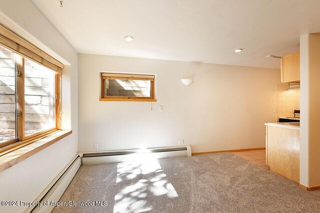 unfurnished dining area featuring a baseboard heating unit and light tile patterned flooring