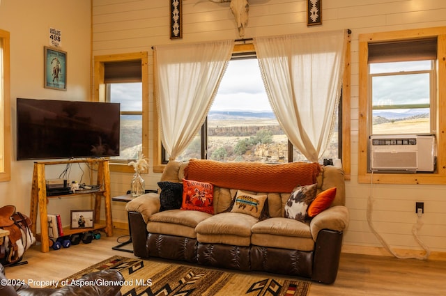 living room with hardwood / wood-style flooring, a mountain view, cooling unit, and wooden walls