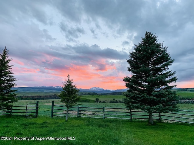 yard at dusk with a mountain view and a rural view