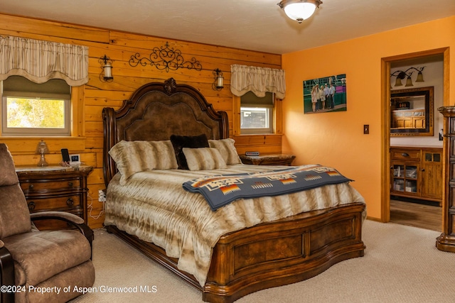 carpeted bedroom featuring wooden walls