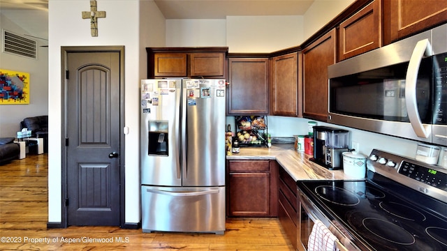 kitchen featuring appliances with stainless steel finishes and light hardwood / wood-style flooring