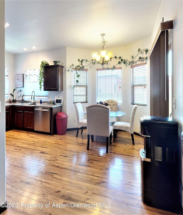 dining space featuring a notable chandelier, light wood-type flooring, and sink