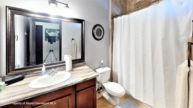 bathroom featuring tile patterned flooring, vanity, and toilet