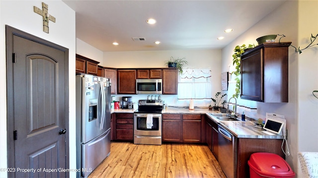 kitchen with wood counters, light hardwood / wood-style floors, sink, and appliances with stainless steel finishes