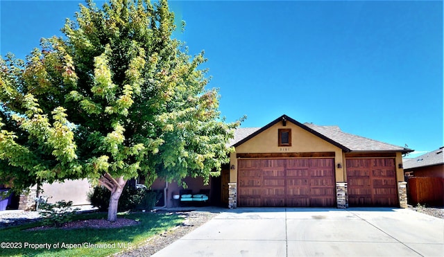 view of property hidden behind natural elements featuring a garage