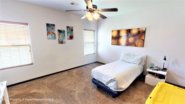 carpeted bedroom featuring ceiling fan and multiple windows