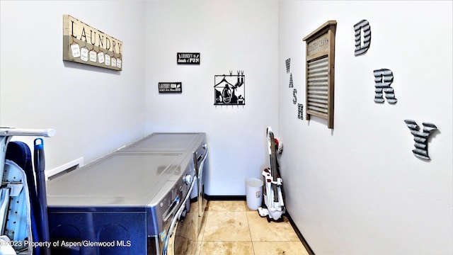 laundry area featuring washing machine and dryer and light tile patterned flooring