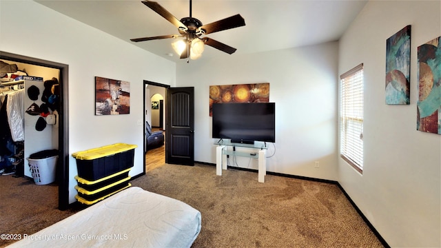 carpeted bedroom featuring ceiling fan and a closet