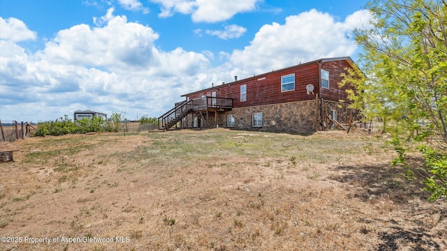 160 Mustang Mesa Trl, Rifle, CO 81650 - rear view of house with stairway, a deck, and stone siding