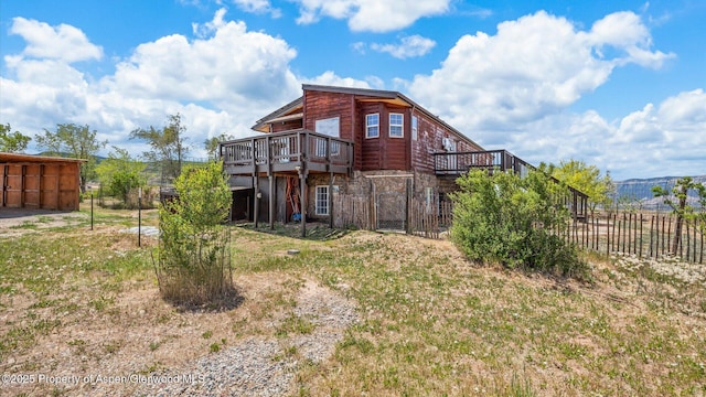 160 Mustang Mesa Trl, Rifle, CO 81650 - back of property featuring a wooden deck and stone siding