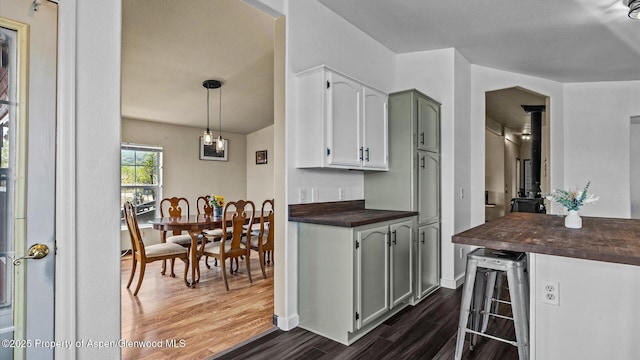 160 Mustang Mesa Trl, Rifle, CO 81650 - kitchen featuring dark wood-style floors, beverage cooler, wood counters, a wood stove, and white cabinets