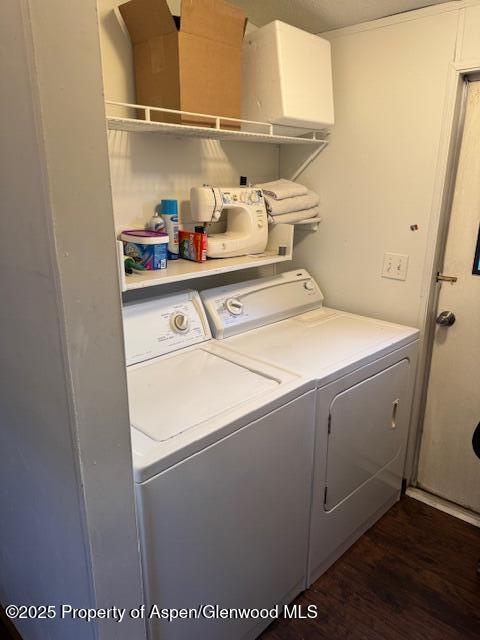 clothes washing area featuring dark wood-type flooring, laundry area, and independent washer and dryer
