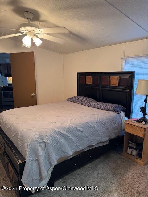 carpeted bedroom featuring a textured ceiling and ceiling fan