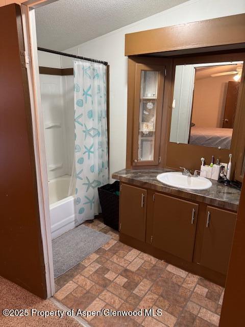 full bath featuring shower / bath combination with curtain, vanity, and a textured ceiling