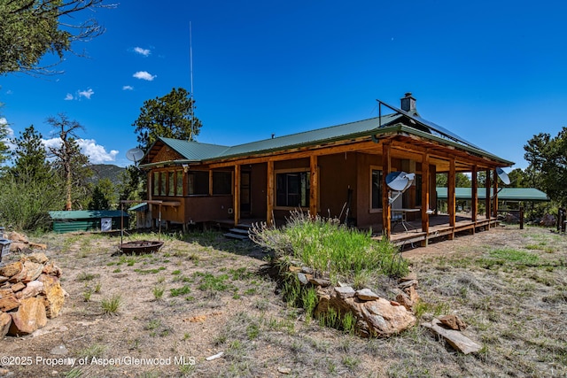 701/700 Bella Vista Ln, Cotopaxi, CO 81223 - rear view of property featuring a fire pit, a chimney, metal roof, and a deck
