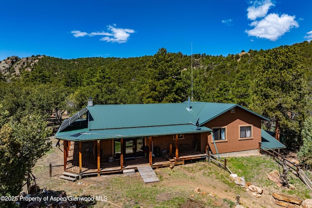 701/700 Bella Vista Ln, Cotopaxi, CO 81223 - back of property with a forest view, metal roof, and a chimney