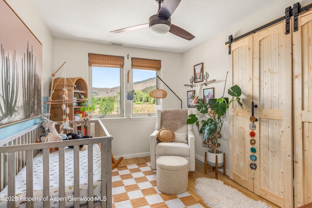 106 Lakeside Ct, Basalt, CO 81621 - bedroom with a barn door, light wood finished floors, ceiling fan, and a mountain view