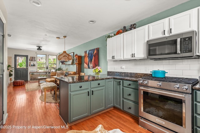 106 Lakeside Ct, Basalt, CO 81621 - kitchen with stainless steel appliances, white cabinetry, a peninsula, backsplash, and light wood-style flooring