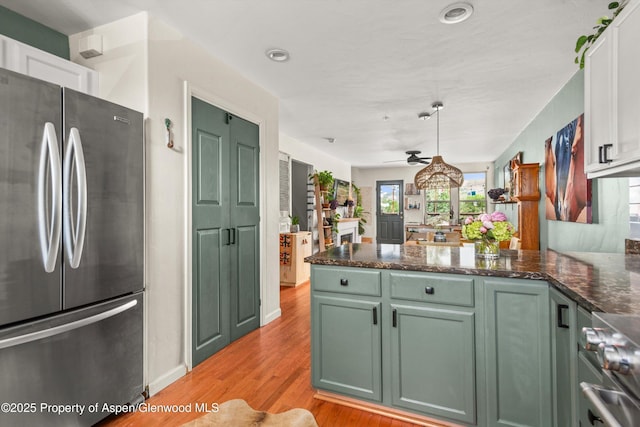106 Lakeside Ct, Basalt, CO 81621 - kitchen with freestanding refrigerator, green cabinets, a peninsula, range, and white cabinetry