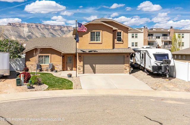 120 Harris Ln, Parachute, CO 81635 - townhome / multi-family property with stucco siding, fence, a garage, driveway, and stone siding
