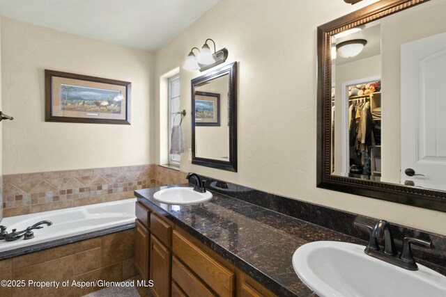 120 Harris Ln, Parachute, CO 81635 - full bathroom featuring a walk in closet, a garden tub, double vanity, and a sink