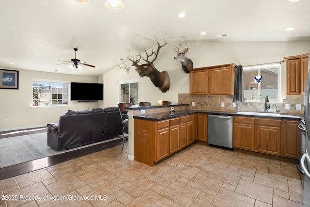 120 Harris Ln, Parachute, CO 81635 - kitchen featuring stainless steel dishwasher, a sink, a peninsula, a ceiling fan, and backsplash