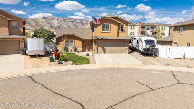 120 Harris Ln, Parachute, CO 81635 - view of front of property featuring stucco siding, stone siding, concrete driveway, an attached garage, and fence